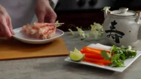 Lock down shot of chef placing skewers of shrimp on cutting board with place  Stock Footage 98247774