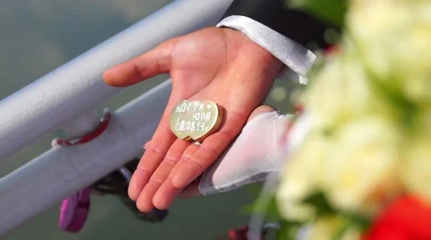 Lock in the form of hearts in the hands of the bride and groom. Stock Footage 48549122