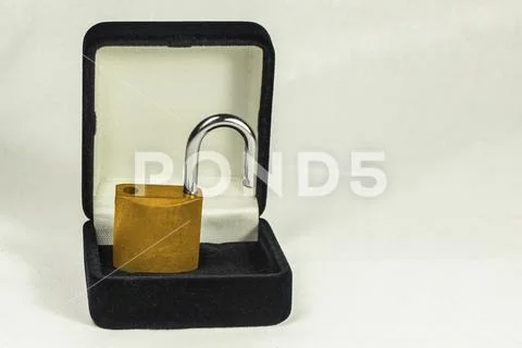 Lock in gift box. Gold padlock with open shackle in jewelry chest. Concept Stock Photos