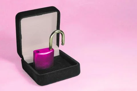 Lock in gift box. Pink padlock with open shackle in jewelry chest. Concept 스톡 사진