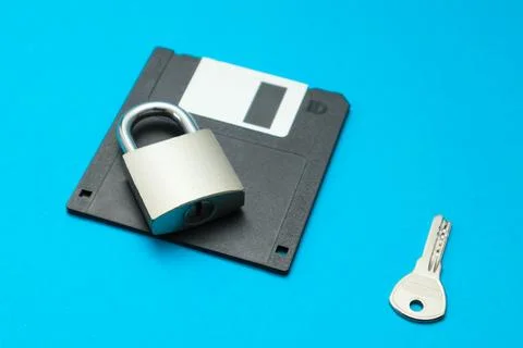The lock with key is on the black retro 3.5" floppy diskette. Cyber securit.. Stock Photos
