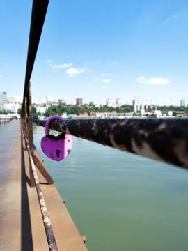Lock on the railing of the bridge over the river. In the far visible city. Lo Stock Photos