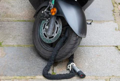 Lockable chain on the front wheel of the scooter Stock Photos