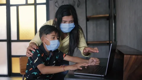 Lockdown and school closures. Mother helping her child with face mask studying Stock-Footage 129153304