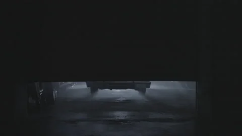 Lockdown Of Garage Door Opening And Car Exiting With Headlights And A Light Rain Video stock 188072986