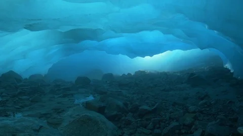 Lockdown of Inside Of Glacier, Rocky Bottom and Blue Tinted Ice Ceiling - Stock Footage 113946538