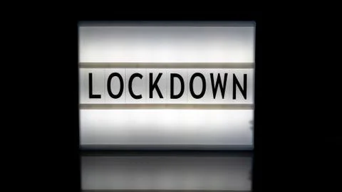 Lockdown letters on a light box on reflective surface Stock Photos