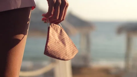 Lockdown is over. Close up of female hand holding protective mask fluttering in Stock Footage 149436784