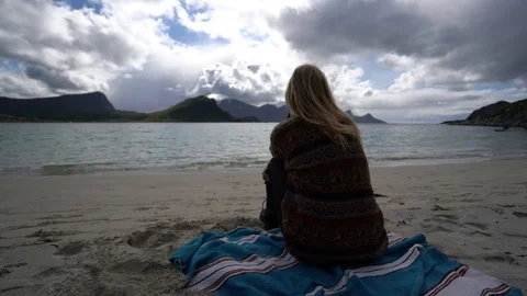 Lockdown shot of a couple sitting on the beach and embracing Stock Footage 114882027