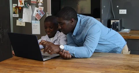 Lockdown shot of father and son using laptop on kitchen counter Stock Footage 120094609