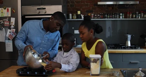 Lockdown shot of father, son and daughter baking cookies in kitchen Stock Footage 120071659