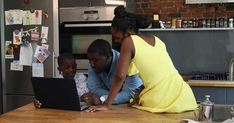 Lockdown shot of father, son and daughter using laptop on kitchen counter Stock Footage 120095653