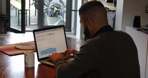 Lockdown shot of focused young man working on laptop at home Stock Footage 119969772
