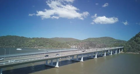 Lockdown shot of land vehicles moving on bridge over sea Stock Footage 122387706