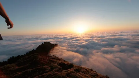 Lockdown shot of man standing on cliff and photographing cloudscape during Stock Footage 96400096