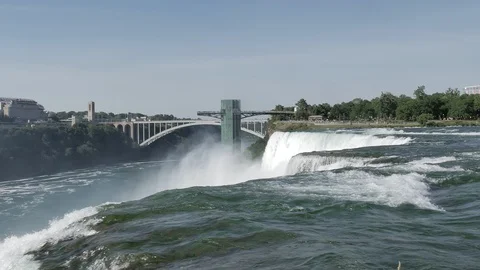 Lockdown shot of Niagara Falls with rainbow bridge in distance Stock Footage 120082259