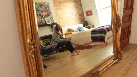 Lockdown shot of reflection of woman using mobile phone and listening music Stock Footage 114860312