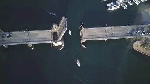Lockdown shot of sailboat passing from a bascule bridge on sea Stock Footage 122471301