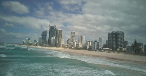 Lockdown shot of sea waves on beach against Cityscape Stock Footage 122387572