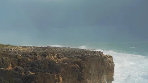 Lockdown shot of sea waves crashing on cliffs on seashore, Cascais, Portugal 스톡 동영상 114852091