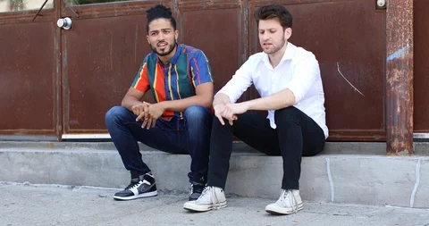 Lockdown shot of two businessmen talking while sitting side by side Stock Footage 114858577