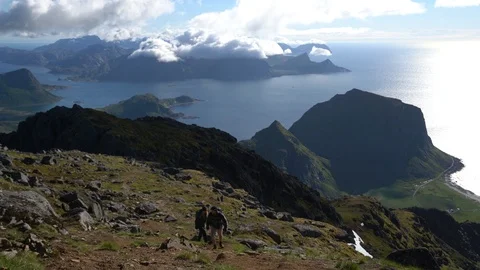 Lockdown shot of two hikers climbing up the hill Stock Footage 114881443