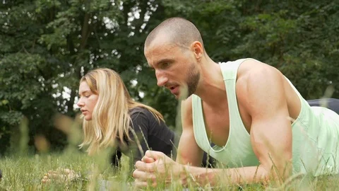 Lockdown shot of two young people resting after doing planks in slow motion Vídeo Stock 114874287