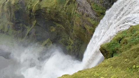 Lockdown shot of waterfall streaming down through virescent hills Video stock 114885038