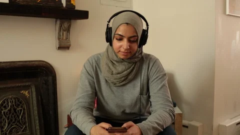 Lockdown shot of woman using mobile phone and listening music at home Stock Footage 114860320