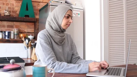 Lockdown shot of young freelancer in hijab using laptop in kitchen Stock Footage 114860066