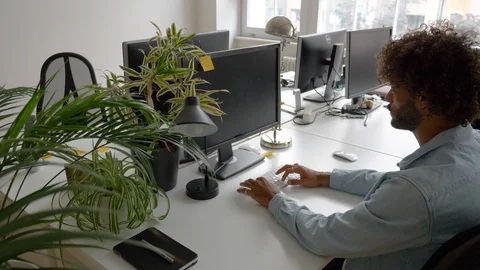 Lockdown shot of young man using computer and young woman joining him in office 스톡 동영상 114872423