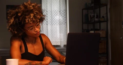 Lockdown shot of young woman using laptop while sitting at a table Stock Footage 120047114
