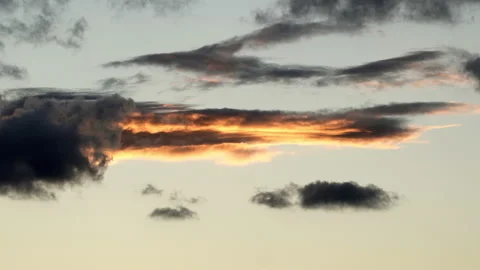 Lockdown Of Thin, Dark Clouds As They Move Across The Sky At Dusk, With Warm Stock Footage