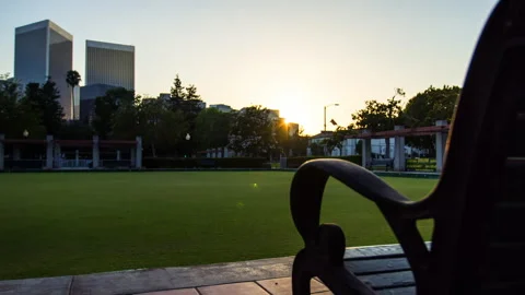 Lockdown Time Lapse Shot Of Bench In Park By Modern Buildings From Day To Night Vídeos de archivo 297588254