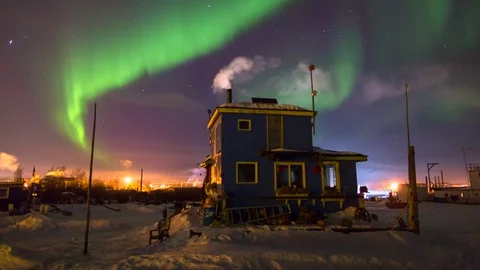 Lockdown time lapse shot of blue house on snow emitting smoke against polar Video stock 130073309