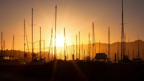 Lockdown Time Lapse Shot Of Sail Boats Arranged Against Mountains During Sunset Stock Footage 160321019