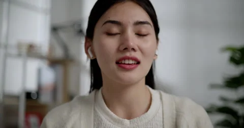 Locked close up shot, Face of Young vlogger female use earphones Stockbeeldmateriaal 240390741