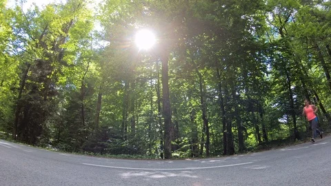 Locked down low angle shot of an overweight woman with pony tail running Stock Footage 109373712