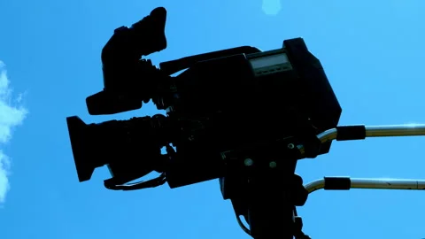 A locked down professional video camera shooting against a blue sky. Video stock 244656715