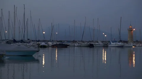 Locked down real time wide shot of boats moored on lake Garda. Lake Garda is the Stock-Footage 122287754