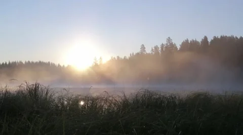 Locked-down shot of fog moving at a lake during sunset Stock Footage 54547409