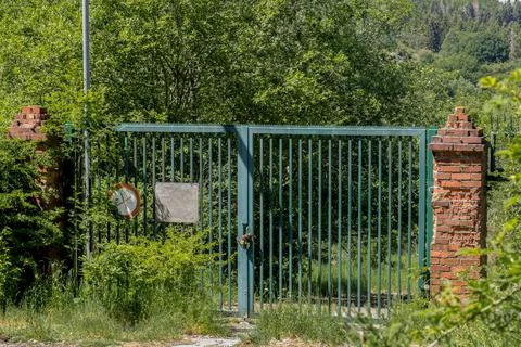 Locked gate of an abandoned object in the forest Stock Photos