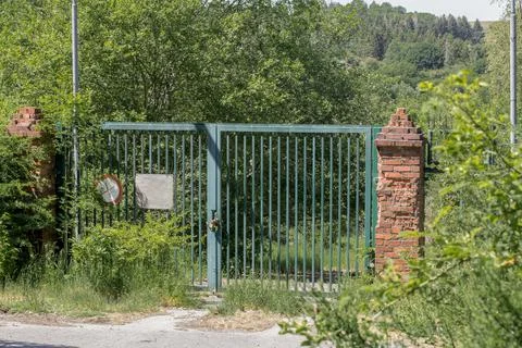 Locked gate of an abandoned object in the forest Stock Photos