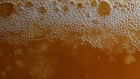 A locked off macro shot of yeast bubbles in active mead fermentation. Stock Footage 127891589
