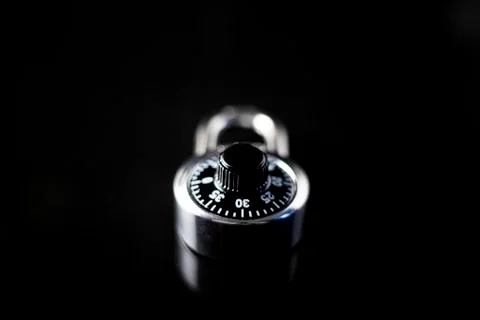 Locked padlock on a black background with reflection on glass Stock Photos