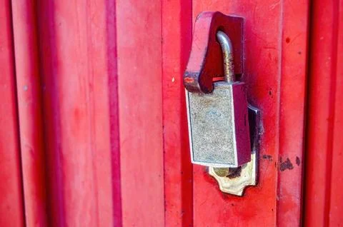 A locked padlock on the red iron harmonica door Stock Photos