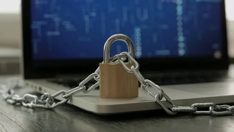 Locked padlock standing on a laptop, with chain going around. Stock-Footage 75693536