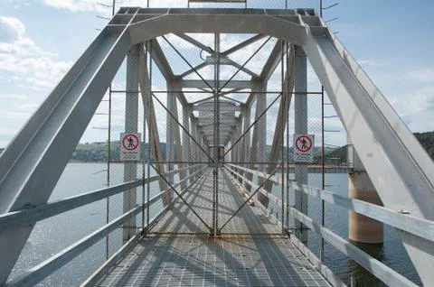 Locked security gates on bridge over lake Stock-Fotos
