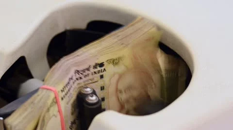 Locked-on shot of Indian currency notes being counted in a machine Stock Footage 30140267