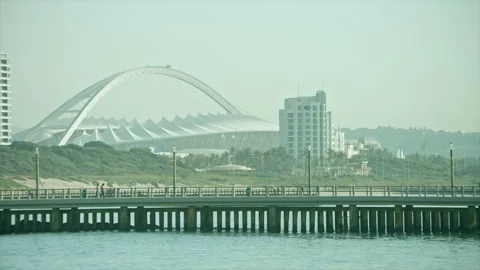 Locked off view of the Moses Mabhida Stadium with a pier in the foreground Stock Footage 311922795